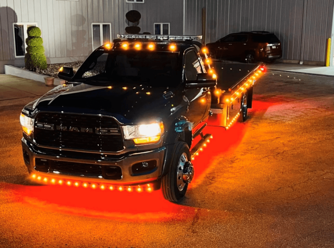 AC’s Towing flatbed truck lit up at night