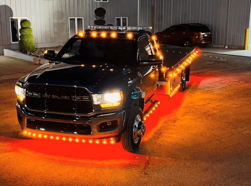 AC’s Towing flatbed truck lit up at night